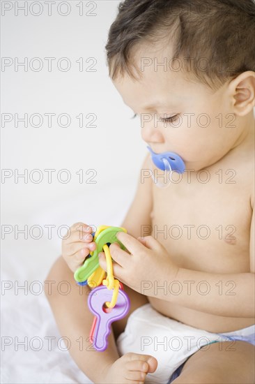 Hispanic baby playing with toy keys