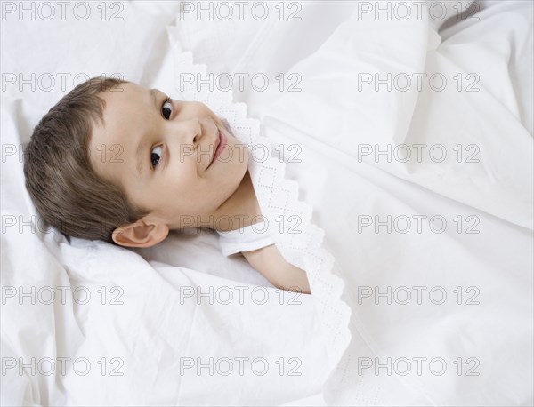 Hispanic boy laying in bed