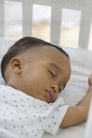 African American baby sleeping in crib