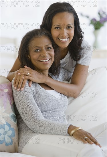 African American mother and adult daughter hugging