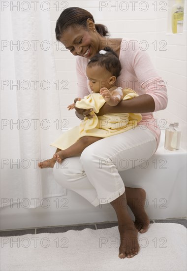 African American grandmother drying off baby