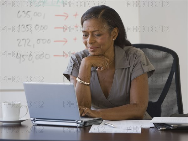 Senior African American businesswoman looking at laptop