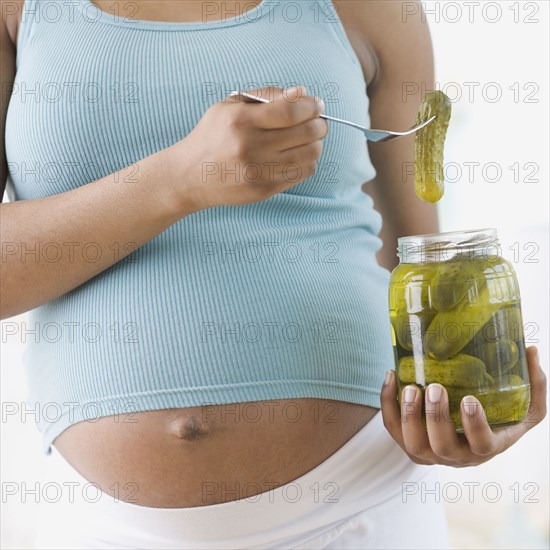 Pregnant African American woman holding pickles