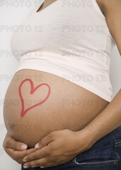 Pregnant African American woman with heart on belly