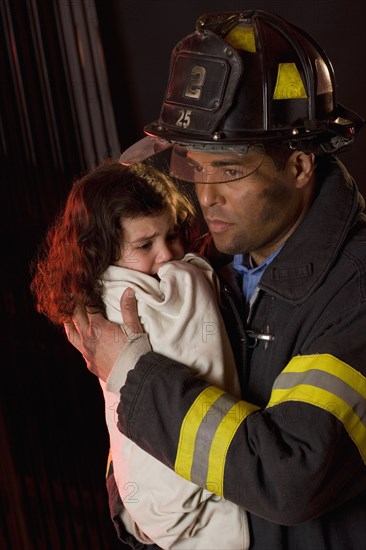 Hispanic male firefighter holding child