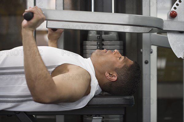 Hispanic man using exercise machine