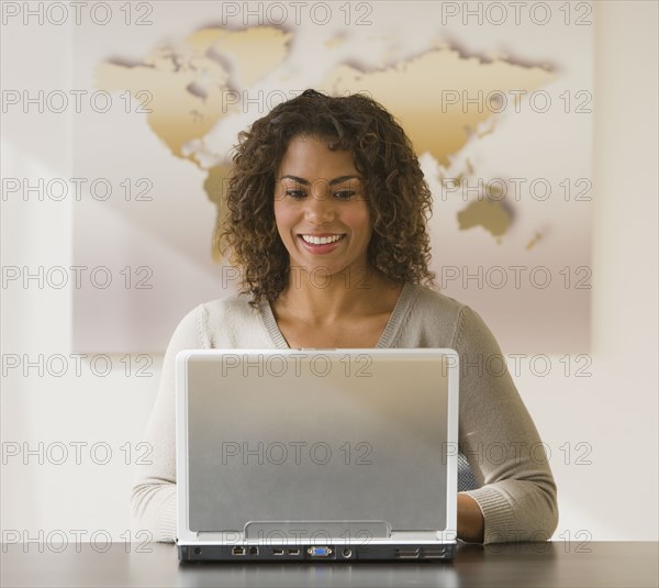 African businesswoman looking at laptop