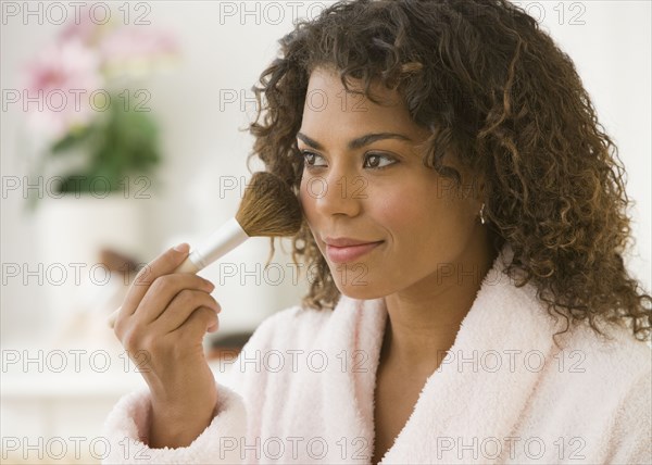 African woman applying makeup