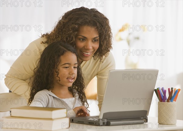 African mother and daughter looking at laptop