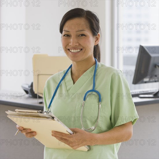 Asian female doctor holding chart