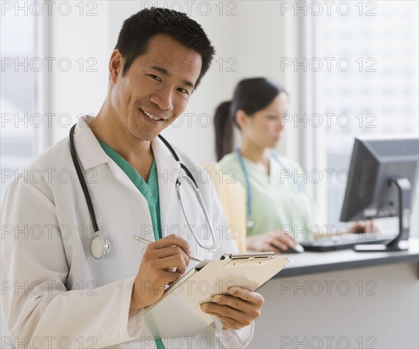 Asian male doctor holding chart