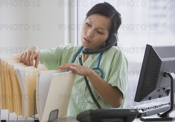 Asian female doctor talking on telephone