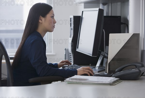 Asian businesswoman looking at computer