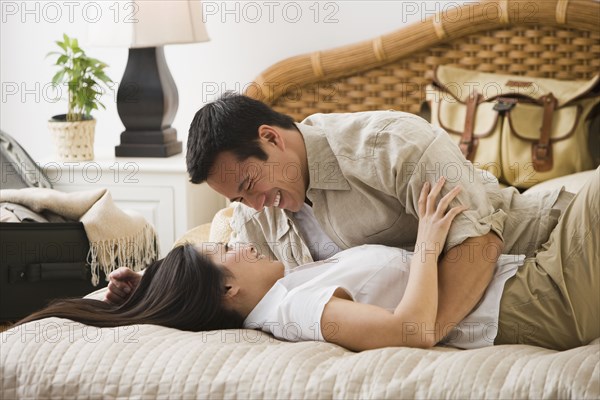 Asian couple hugging on bed