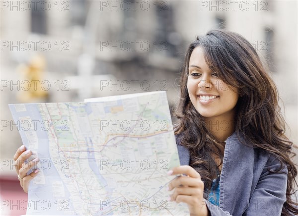 Mixed Race woman looking at map