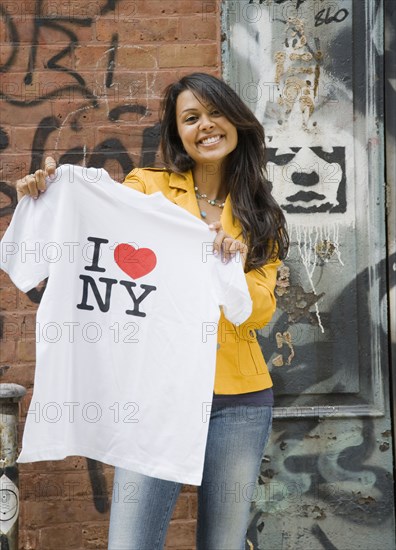 Mixed Race woman holding t-shirt