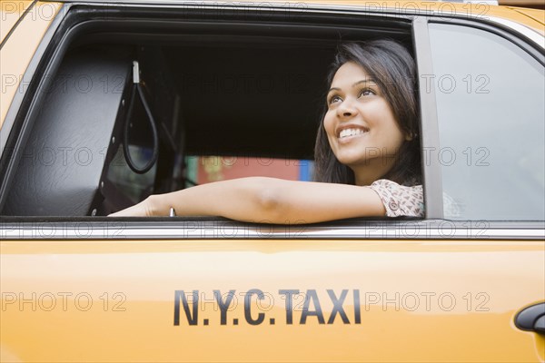 Mixed Race woman looking out taxi cab window