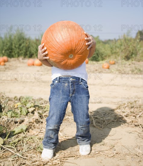 Hispanic child holding pumpkin