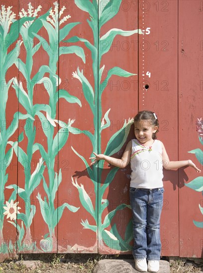 Hispanic girl in front of height marker