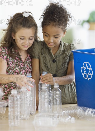 Multi-ethnic girl recycling bottles