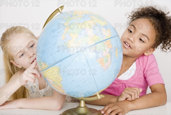 Multi-ethnic girls looking at globe