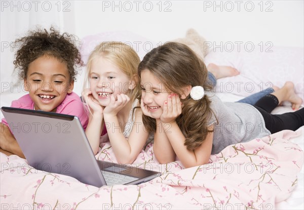 Multi-ethnic girls looking at laptop