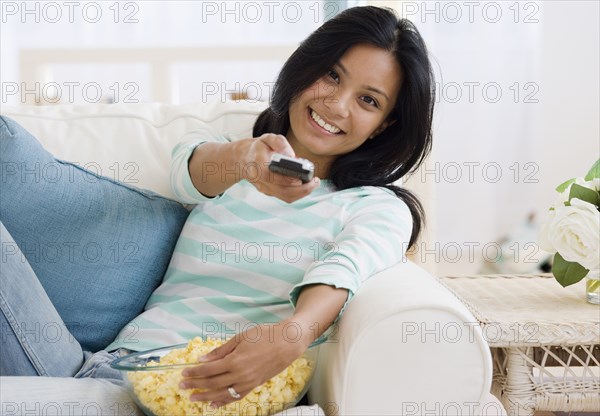 Pacific Islander woman pointing remote control