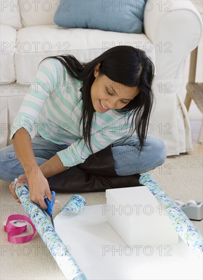 Pacific Islander woman wrapping gift