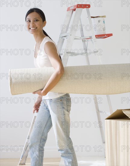 Pacific Islander woman carrying rug