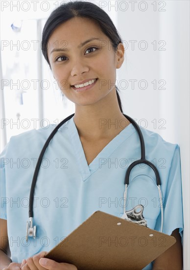 Pacific Islander female doctor holding chart