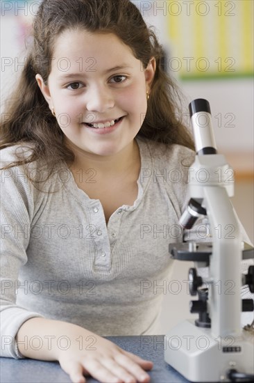 Hispanic girl next to microscope