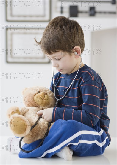 Hispanic boy with teddy bear in doctor's office