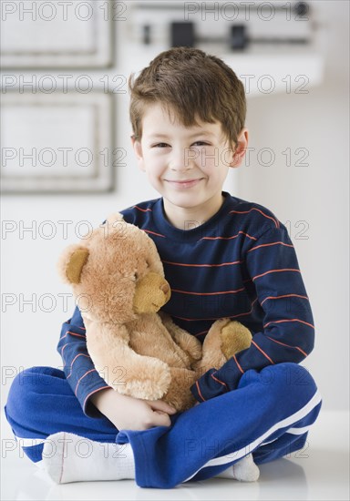 Hispanic boy with teddy bear in doctor's office