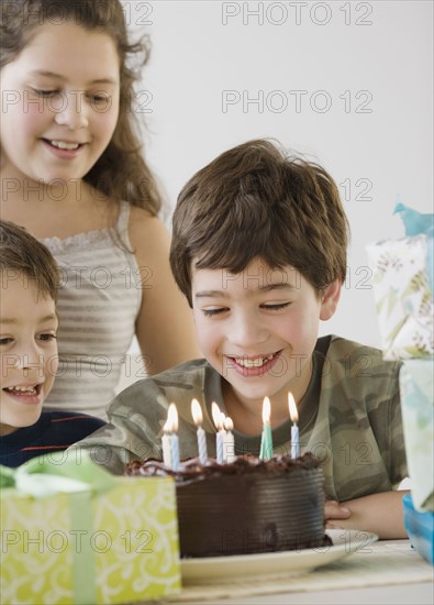 Hispanic boy looking at birthday cake