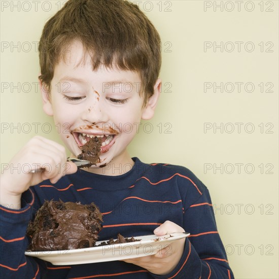 Hispanic boy eating cake