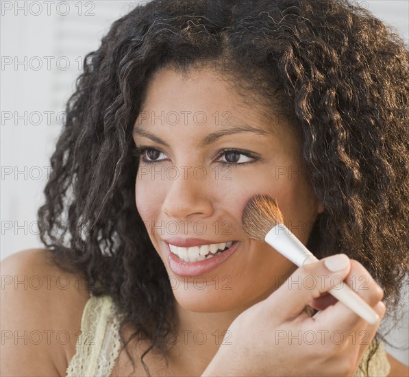 African woman applying makeup
