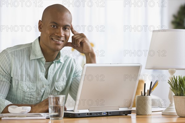 African man next to laptop