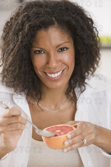 African woman eating grapefruit