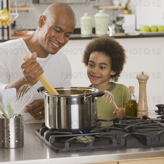 African father and son making pasta