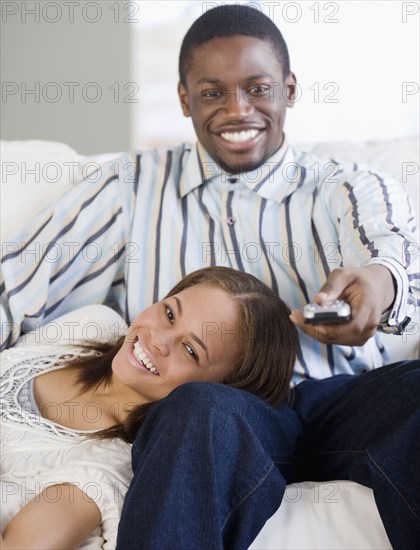 African couple watching television