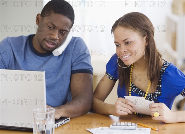 African couple paying bills