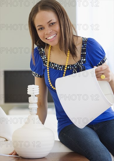 African woman holding lampshade