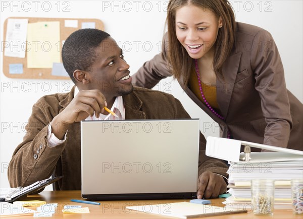 African businesspeople looking at laptop