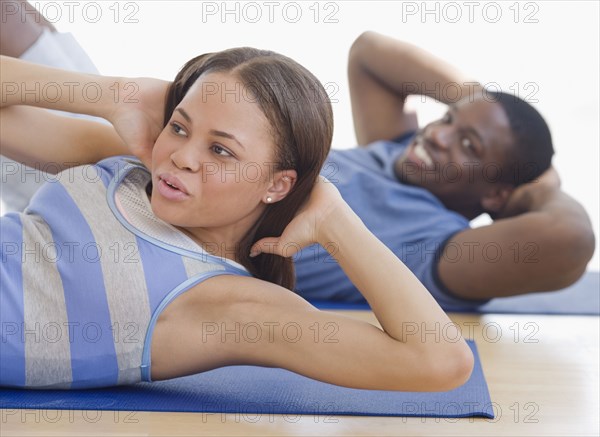 African couple exercising on mats