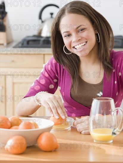 African woman juicing oranges