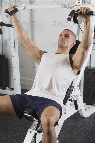 Hispanic man exercising in gym