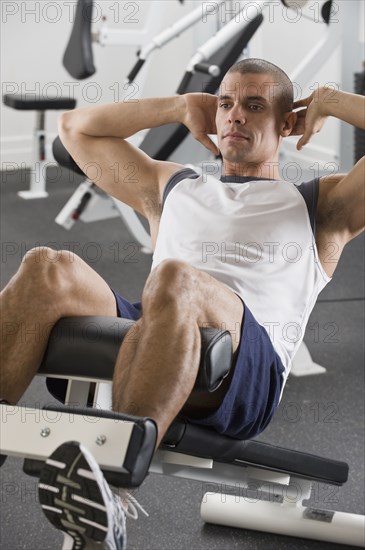 Hispanic man exercising in gym