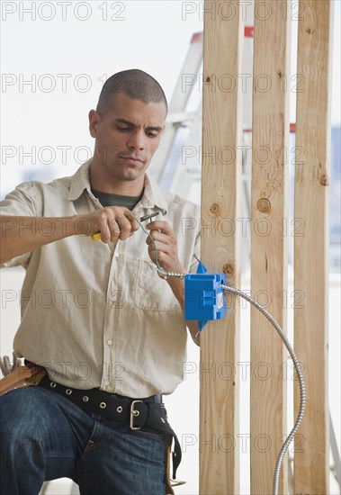 Hispanic male electrician working in new construction