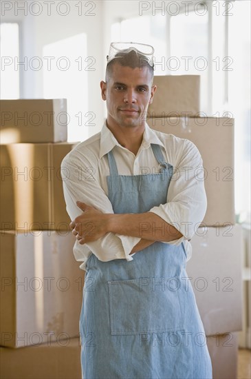 Hispanic man wearing apron and protective eyewear