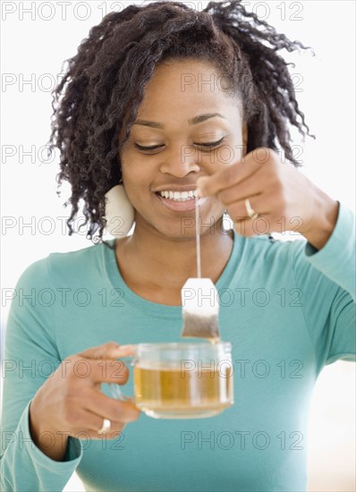 African woman holding tea bag